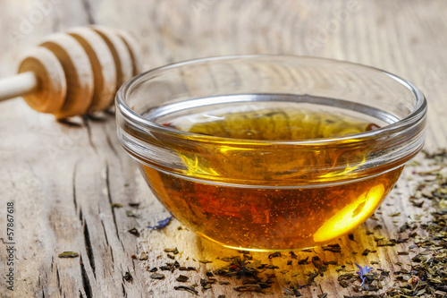 Photo: Bowl of honey on wooden table. Symbol of healthy living Bowl of honey on wooden table. Symbol of healthy living