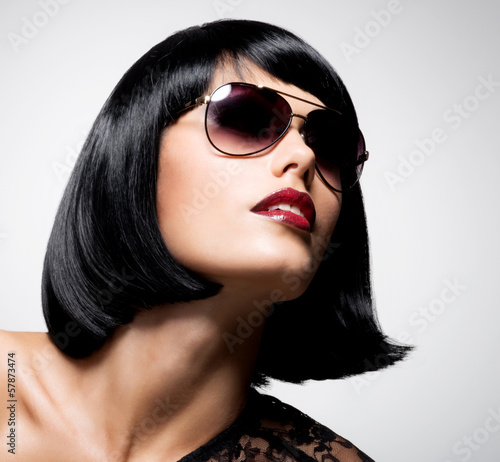 Photo: beautiful brunette woman with shot hairstyle with red sunglasses beautiful brunette woman with shot hairstyle with red sunglasses