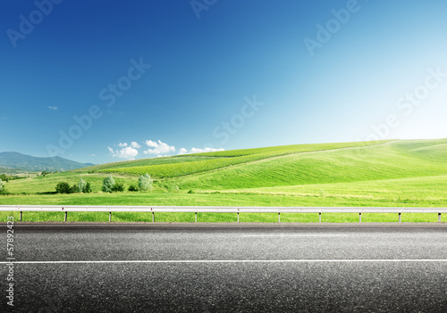 Photo: asphalt road and perfect green field asphalt road and perfect green field