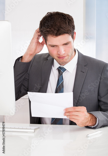 Photo: Businessman Holding Paper Businessman Holding Paper