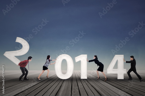 Photo: Businesspeople arrange new year 2014 Businesspeople arrange new year 2014