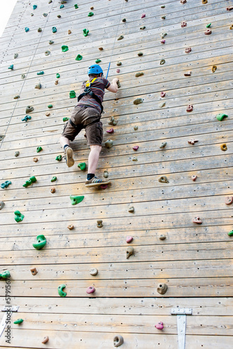 Photo: Young man climbing outdoor climbing wall Young man climbing outdoor climbing wall