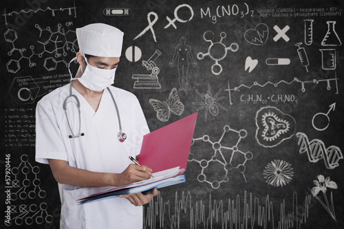 Photo: Male doctor standing with folder Male doctor standing with folder