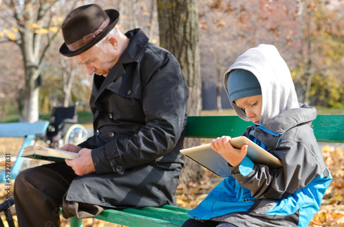 Photo: Cute young boy reading an e-book on a tablet Cute young boy reading an e-book on a tablet