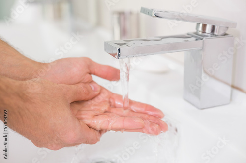 Photo: Washing hands under running water at bathroom sink Washing hands under running water at bathroom sink