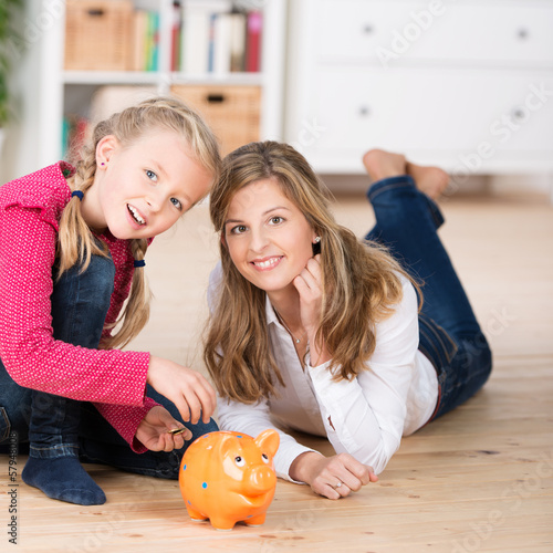 Photo: mutter und kind mit sparschwein mutter und kind mit sparschwein