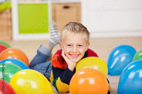 Photo: süßer kleiner junge liegt zwischen luftballons süßer kleiner junge liegt zwischen luftballons