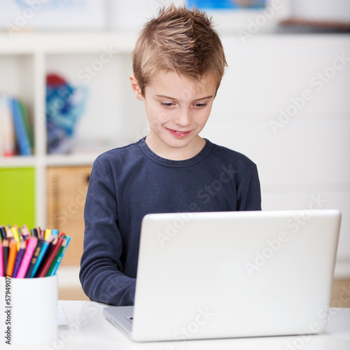 Photo: kleiner junge mit laptop im kinderzimmer kleiner junge mit laptop im kinderzimmer