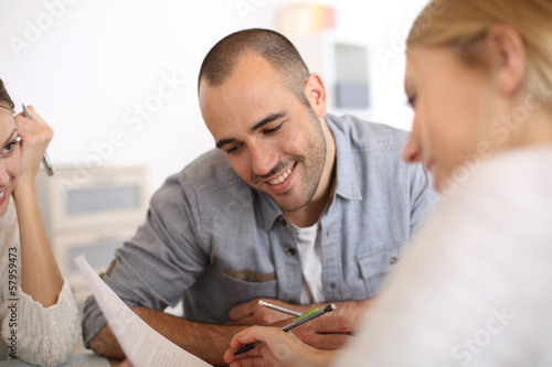 Photo: Man reading contract commented by business partner Man reading contract commented by business partner
