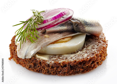 Photo: brown bread canape with anchovies decorated with red onion and d brown bread canape with anchovies decorated with red onion and d