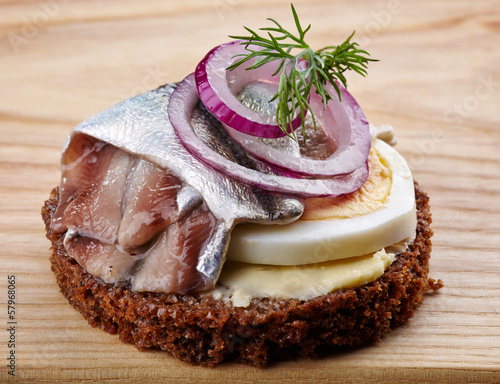 Photo: brown bread canape with anchovies decorated with red onion and d brown bread canape with anchovies decorated with red onion and d