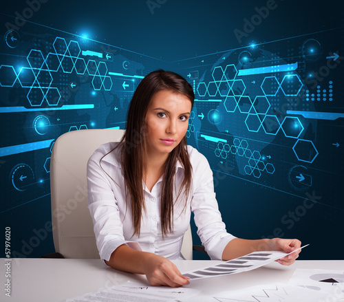 Photo: Businesswoman doing paperwork with futuristic background Businesswoman doing paperwork with futuristic background