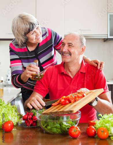 Photo: happy married mature couple cooking together happy married mature couple cooking together