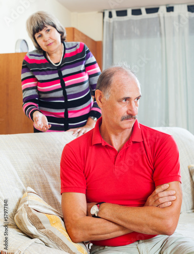 Photo: Mature couple after quarrel in living room Mature couple after quarrel in living room