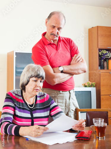 Photo: mature couple reading financial document mature couple reading financial document