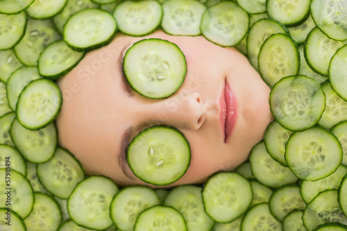 Photo: Beautiful woman with facial mask of cucumber slices on face Beautiful woman with facial mask of cucumber slices on face