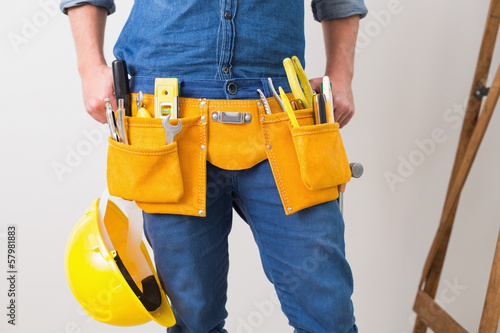 Photo: Mid section of handyman with toolbelt and hard hat Mid section of handyman with toolbelt and hard hat