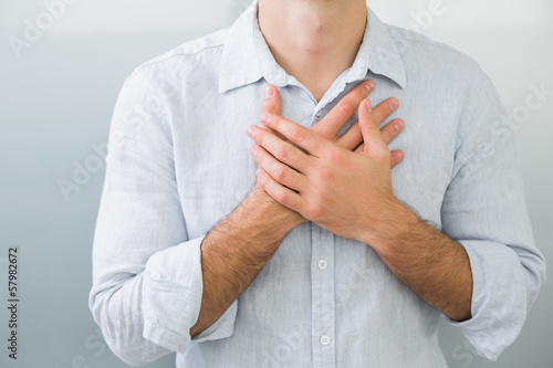 Photo: Mid section of a man with chest pain Mid section of a man with chest pain