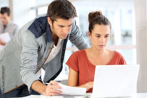 Photo: Business team in office working on laptop Business team in office working on laptop