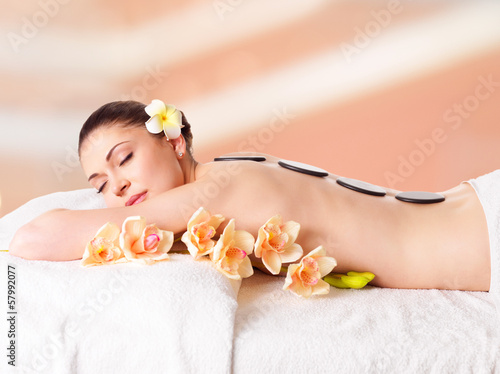 Photo: woman relaxing in spa salon with hot stones woman relaxing in spa salon with hot stones