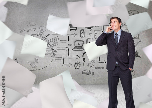 Photo: Composite image of happy businessman phoning Composite image of happy businessman phoning