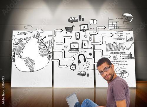 Photo: Composite image of man wearing glasses sitting on floor using la Composite image of man wearing glasses sitting on floor using la