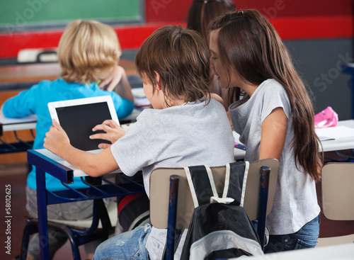 Photo: Schoolchildren Using Digital Tablet In Classroom Schoolchildren Using Digital Tablet In Classroom