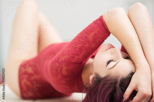 Photo: Sensual redhead woman posing on table with red lingerie. Sensual redhead woman posing on table with red lingerie.