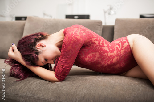 Photo: Sensual redhead woman posing on sofa with red lingerie. Sensual redhead woman posing on sofa with red lingerie.