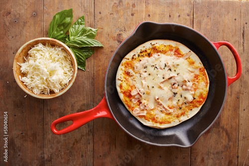 Photo: Cooked mozzarella and ham pizza on a skillet Cooked mozzarella and ham pizza on a skillet