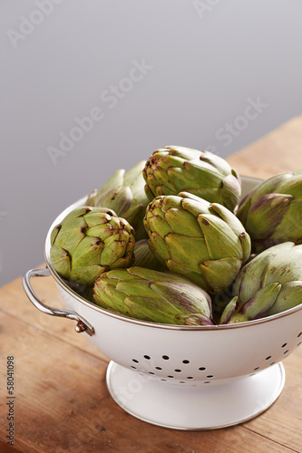 Photo: Raw pile of artichokes on colander Raw pile of artichokes on colander