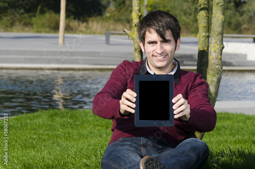 Photo: junger mann präsentiert tablet junger mann präsentiert tablet