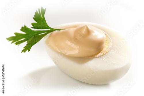 Photo: Hard boiled Egg on white background with potherb ans mayonnaise Hard boiled Egg on white background with potherb ans mayonnaise