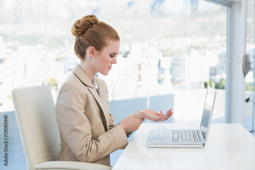 Photo: Businesswoman suffering from wrist pain in the office Businesswoman suffering from wrist pain in the office