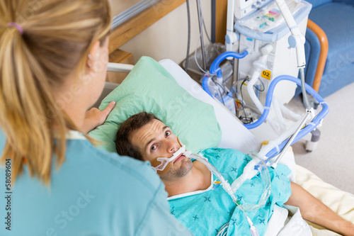 Photo: Patient Looking At Nurse As She Adjusts His Pillow Patient Looking At Nurse As She Adjusts His Pillow