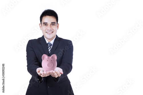 Photo: Businessman holding piggy bank Businessman holding piggy bank