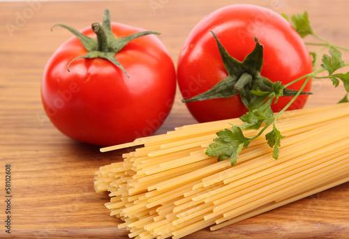 Photo: Spaghetti and tomatoes on board. Spaghetti and tomatoes on board.