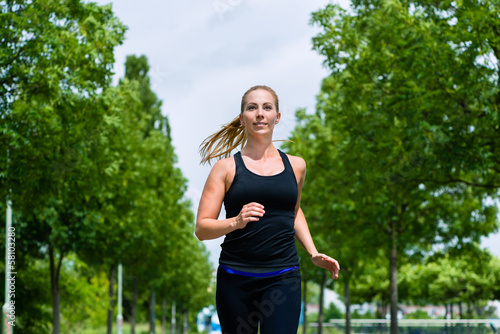Photo: Sport und Fitness - Junge Frau joggt im Park Sport und Fitness - Junge Frau joggt im Park