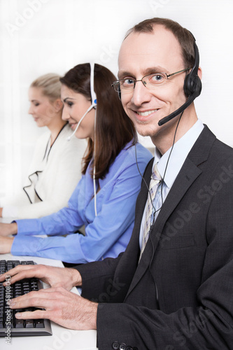 Photo: Mitarbeiter in einem Callcenter - Mann mit Headset Mitarbeiter in einem Callcenter - Mann mit Headset