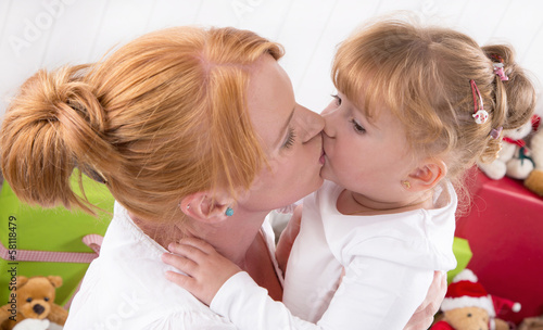 Photo: Mutter und Tochter geben sich einen Kuss Mutter und Tochter geben sich einen Kuss