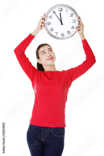 Photo: Attractive young woman holding a clock. Attractive young woman holding a clock.