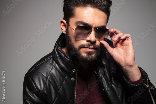 Photo: man with long beard fixing or putting on his sunglasses man with long beard fixing or putting on his sunglasses