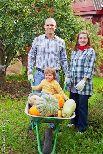 Photo: Happy parents and child with harvest Happy parents and child with harvest