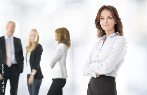 Photo: Confident businesswoman background with her colleagues Confident businesswoman background with her colleagues