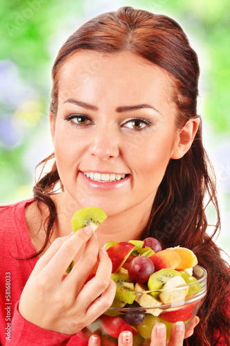 Photo: Young woman eating fruit salad Young woman eating fruit salad