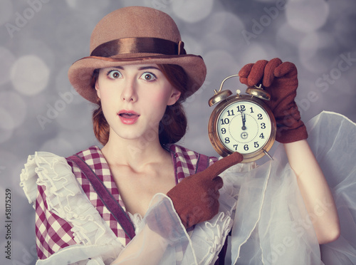 Photo: Beautiful redhead women with clock. Beautiful redhead women with clock.