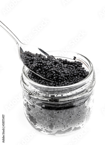 Photo: Black caviar in glass jar with spoon isolated on white Black caviar in glass jar with spoon isolated on white