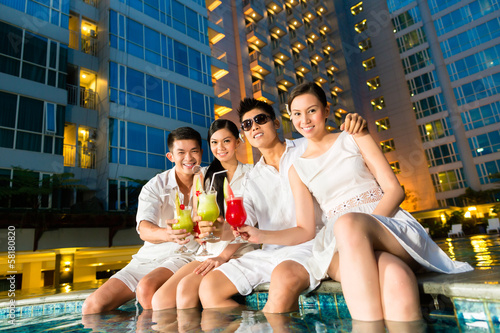 Photo: Chinese couples drinking cocktails in hotel pool bar Chinese couples drinking cocktails in hotel pool bar