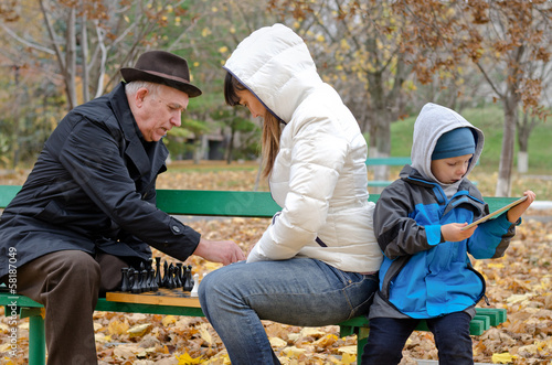 Photo: Boy sitting his mother and grandfather play tablet computer Boy sitting his mother and grandfather play tablet computer