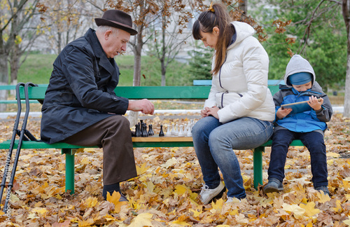 Photo: Boy sitting his mother and grandfather play tablet computer Boy sitting his mother and grandfather play tablet computer
